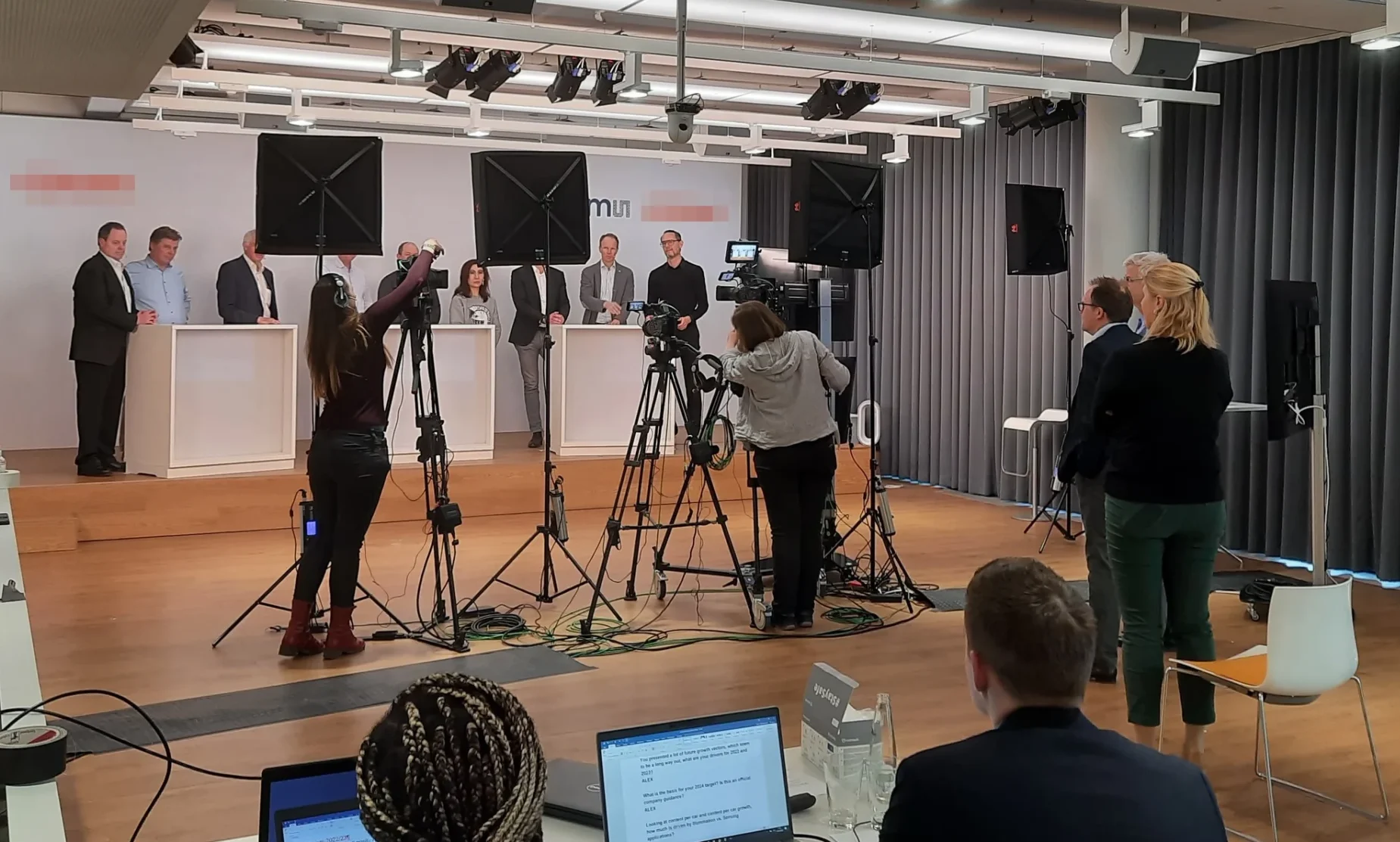 Professionelles Kamerateam bei der Livestream-Produktion einer digitalen Hauptversammlung mit Bühne, Beleuchtung und Publikum