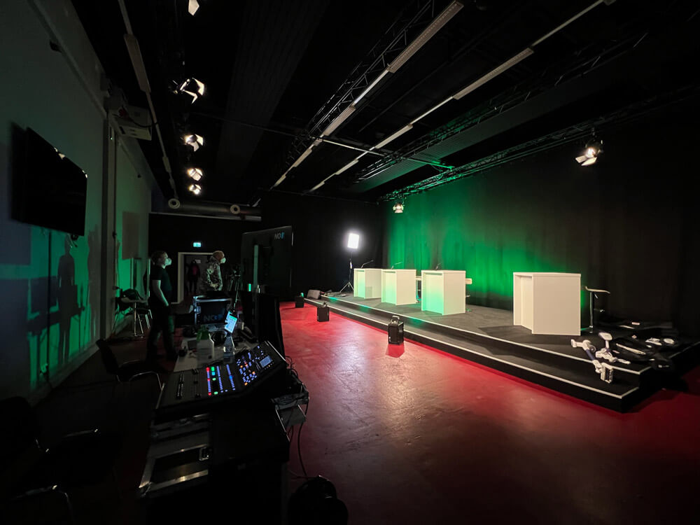 Professionelles Livestream-Studio mit beleuchteter Bühne, Regiepult und moderner Veranstaltungstechnik