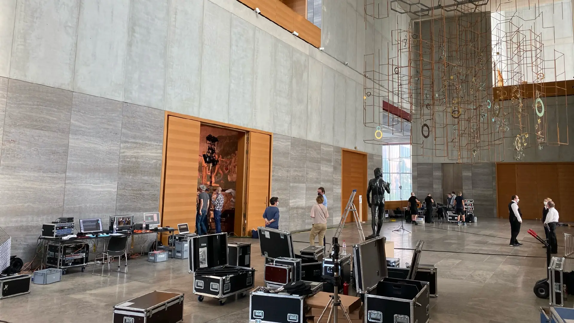 Technisches Setup für eine Veranstaltung im Museum: NC3-Team mit Monitoren, Cases und Equipment in großer Halle mit Kunstinstallation.